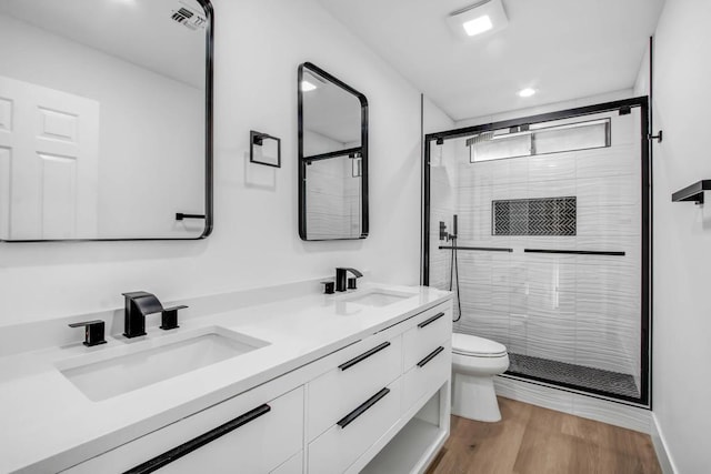 bathroom featuring vanity, an enclosed shower, wood-type flooring, and toilet