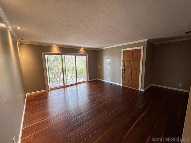 spare room featuring crown molding, dark hardwood / wood-style floors, and a textured ceiling