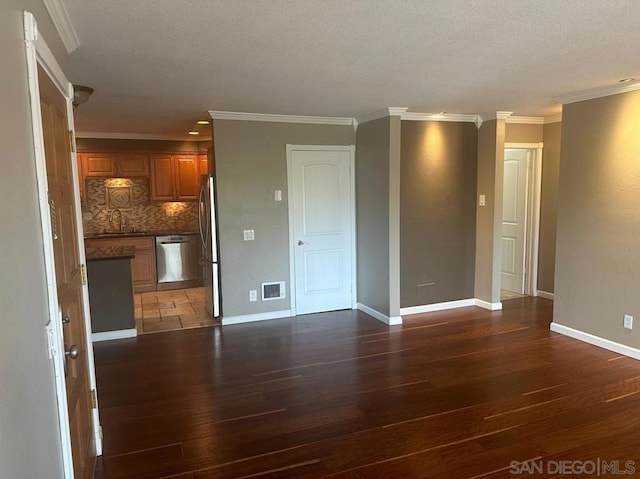 unfurnished living room featuring ornamental molding, dark hardwood / wood-style flooring, and sink