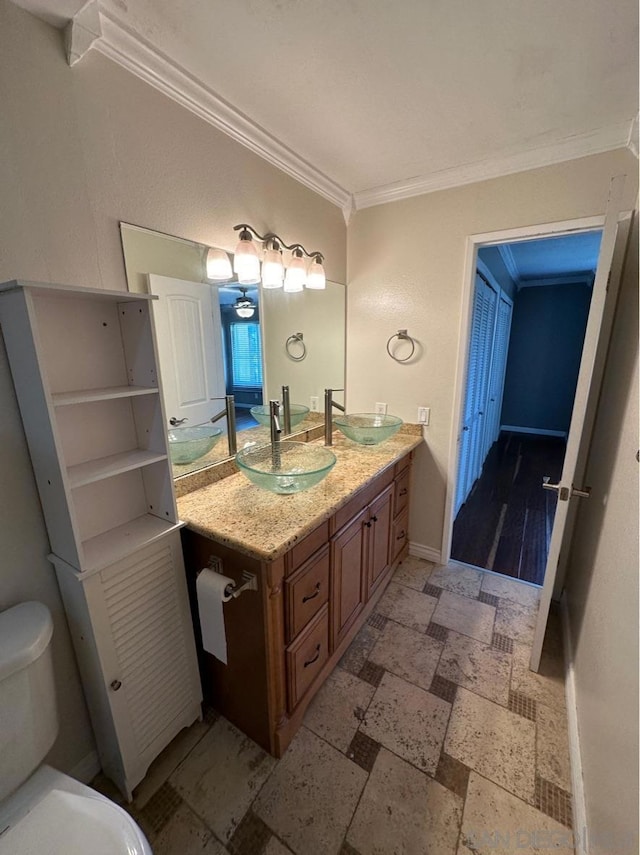 bathroom featuring crown molding, vanity, and toilet