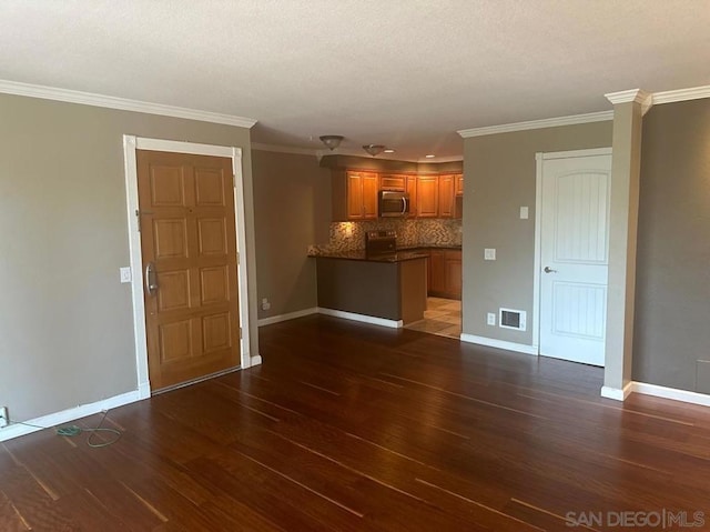 unfurnished living room with dark hardwood / wood-style flooring and crown molding