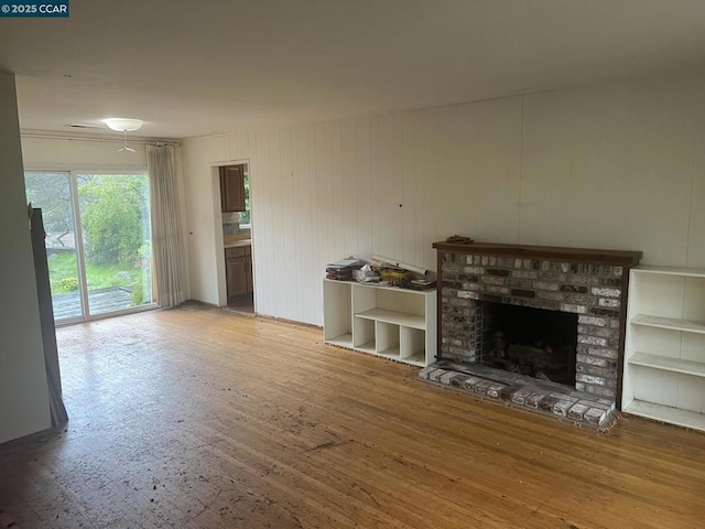 unfurnished living room featuring wood-type flooring and a fireplace