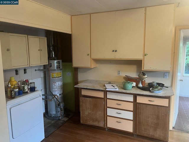 kitchen with dark hardwood / wood-style flooring, cream cabinets, gas water heater, and fridge