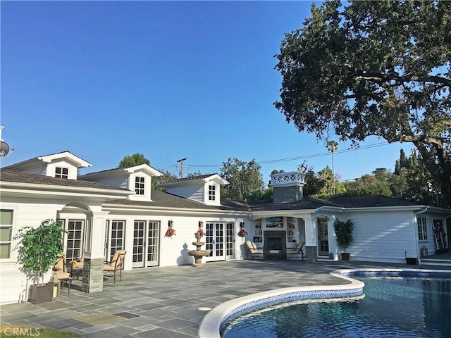 rear view of property with french doors and a patio