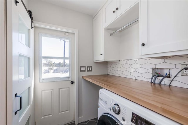 washroom featuring a barn door, cabinets, and washer / clothes dryer