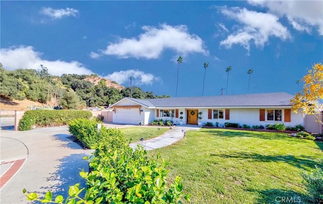 single story home with a garage and a front lawn