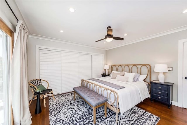 bedroom with dark hardwood / wood-style flooring, ornamental molding, a closet, and ceiling fan