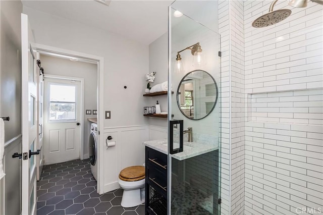 bathroom featuring washer / clothes dryer, vanity, an enclosed shower, toilet, and tile patterned floors