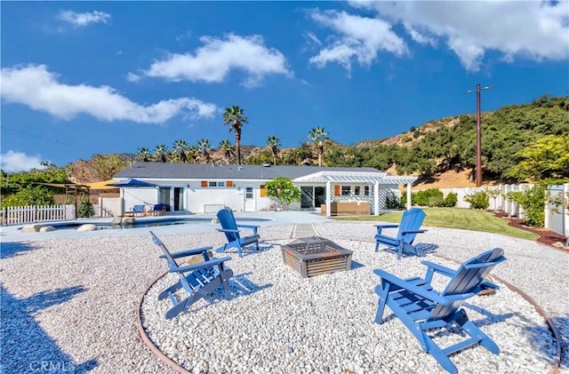 rear view of house featuring a fenced in pool, a patio, an outdoor fire pit, and a pergola