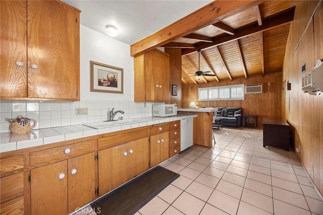 kitchen featuring sink, wood walls, tasteful backsplash, tile counters, and white appliances