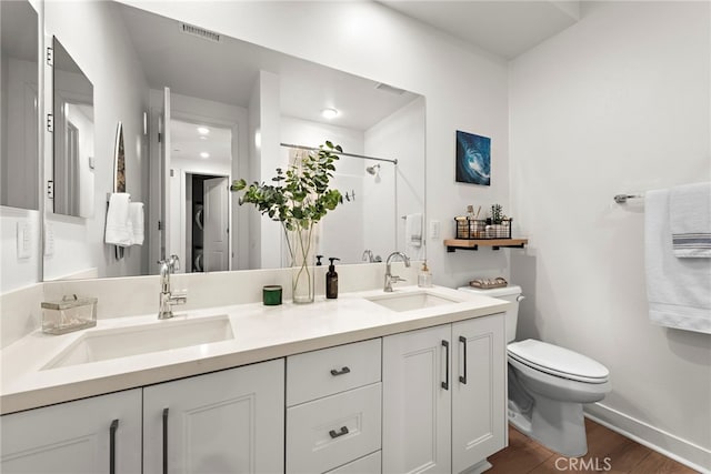 bathroom featuring vanity, wood-type flooring, toilet, and walk in shower