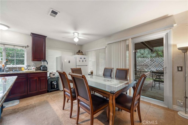 dining space featuring ceiling fan and sink