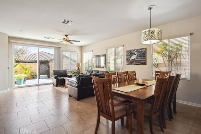 tiled dining space featuring ceiling fan and plenty of natural light