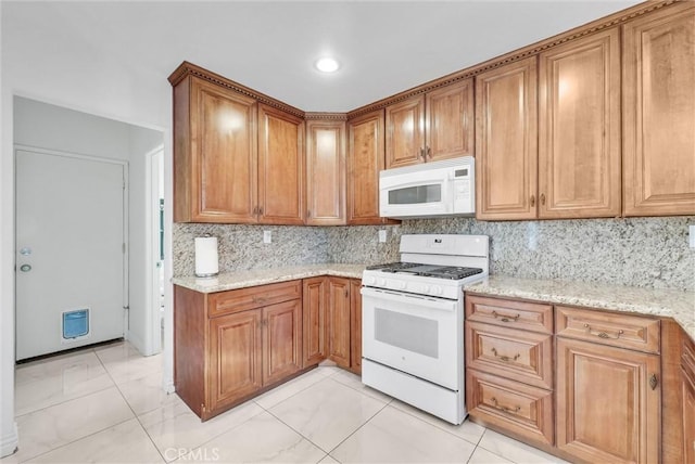 kitchen featuring light stone counters, backsplash, white appliances, and light tile patterned floors