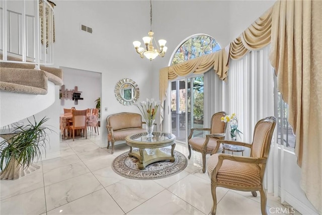 living area with a notable chandelier and a towering ceiling