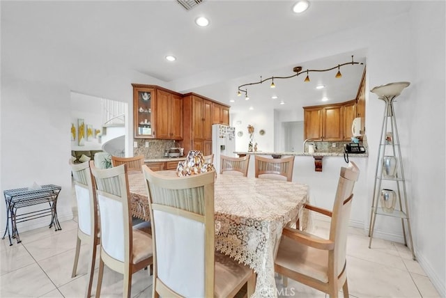 dining space featuring sink and light tile patterned floors