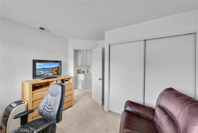 carpeted office space featuring a textured ceiling