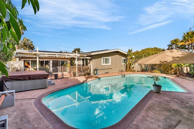 view of swimming pool featuring a hot tub and a patio area