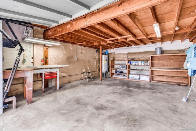 basement with strapped water heater and a workshop area