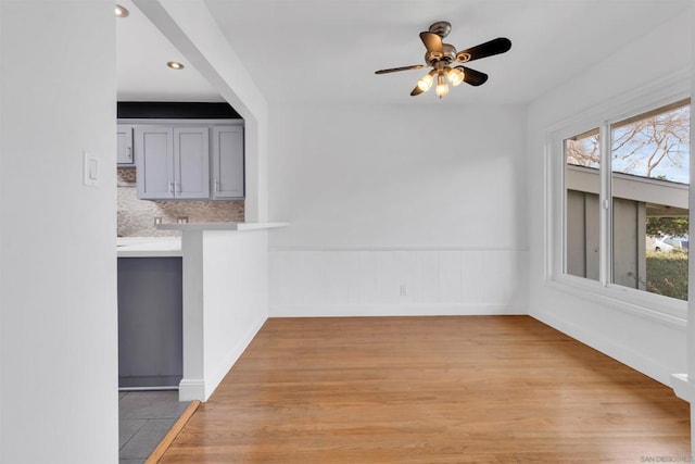 unfurnished dining area featuring ceiling fan and light hardwood / wood-style floors