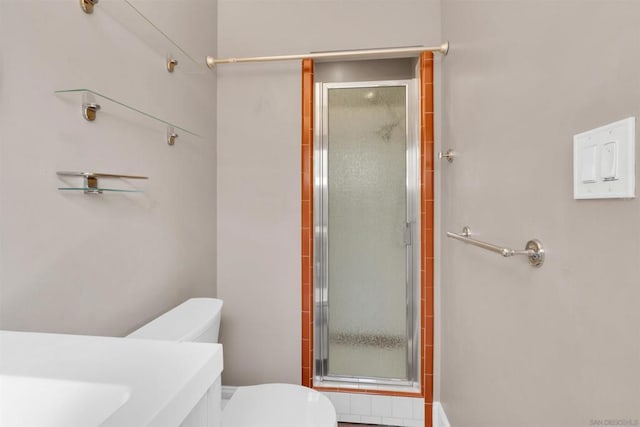 bathroom with vanity, a shower with door, and toilet