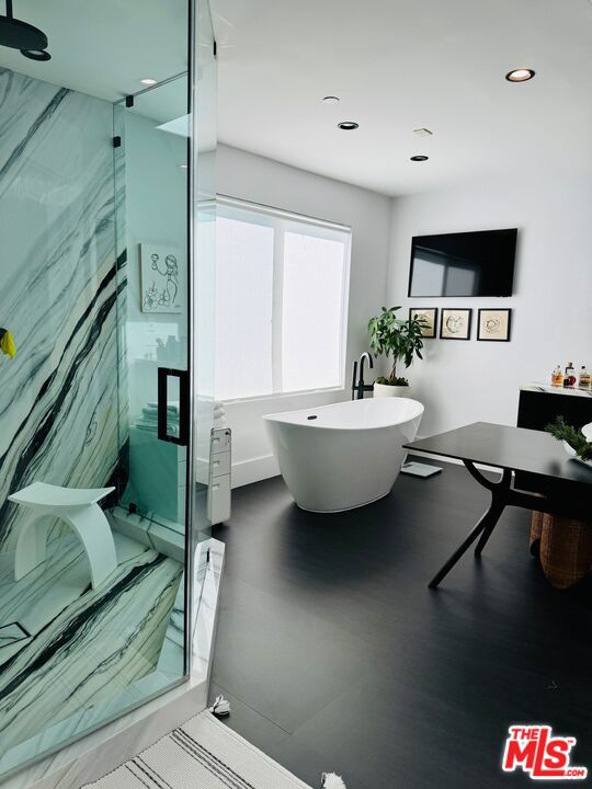 bathroom featuring wood-type flooring and shower with separate bathtub