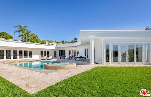 back of house featuring a lawn, outdoor lounge area, a patio, a pool with hot tub, and french doors