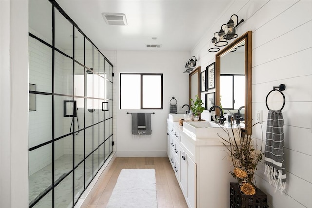 bathroom with vanity, hardwood / wood-style floors, and a tile shower