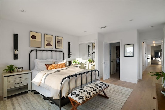 bedroom with light wood-type flooring and a closet