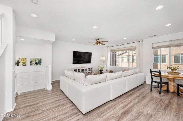 living room featuring ceiling fan and light hardwood / wood-style flooring