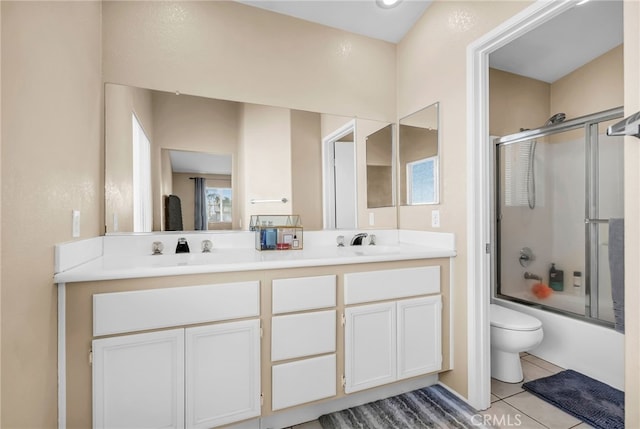 full bathroom with vanity, tile patterned flooring, toilet, and combined bath / shower with glass door