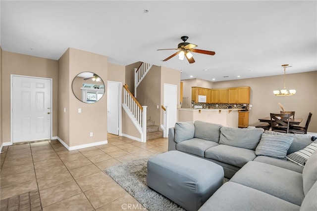 tiled living room featuring ceiling fan with notable chandelier