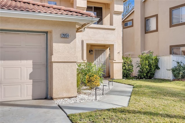 property entrance featuring a garage and a lawn