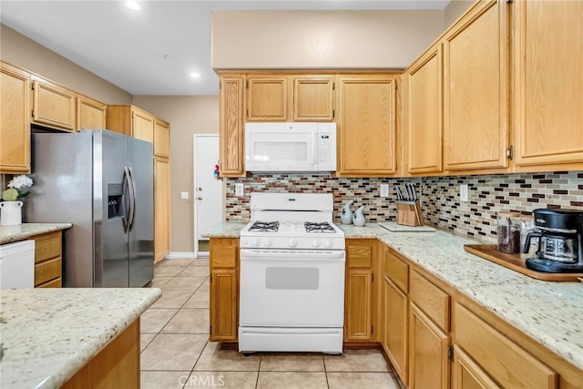 kitchen featuring tasteful backsplash, light tile patterned floors, and white appliances