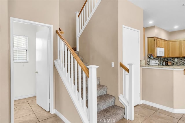 stairway featuring tile patterned flooring