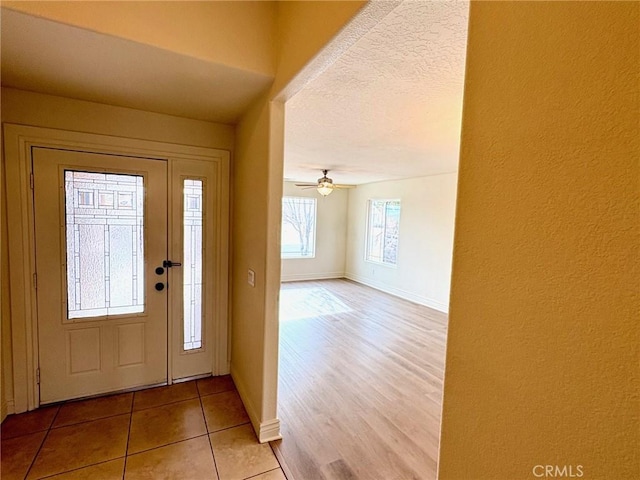 tiled entryway featuring ceiling fan and a textured ceiling