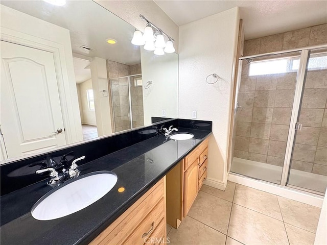 bathroom featuring tile patterned flooring, vanity, a wealth of natural light, and walk in shower