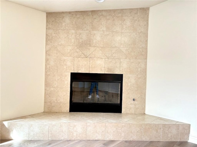 interior details featuring a tile fireplace