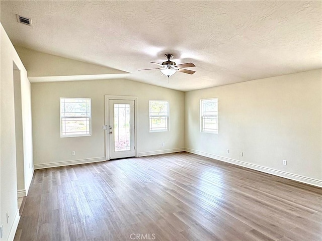 spare room with hardwood / wood-style floors, plenty of natural light, ceiling fan, and vaulted ceiling