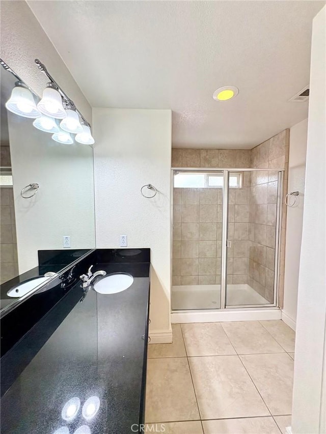 bathroom with tile patterned flooring, vanity, and a shower with door