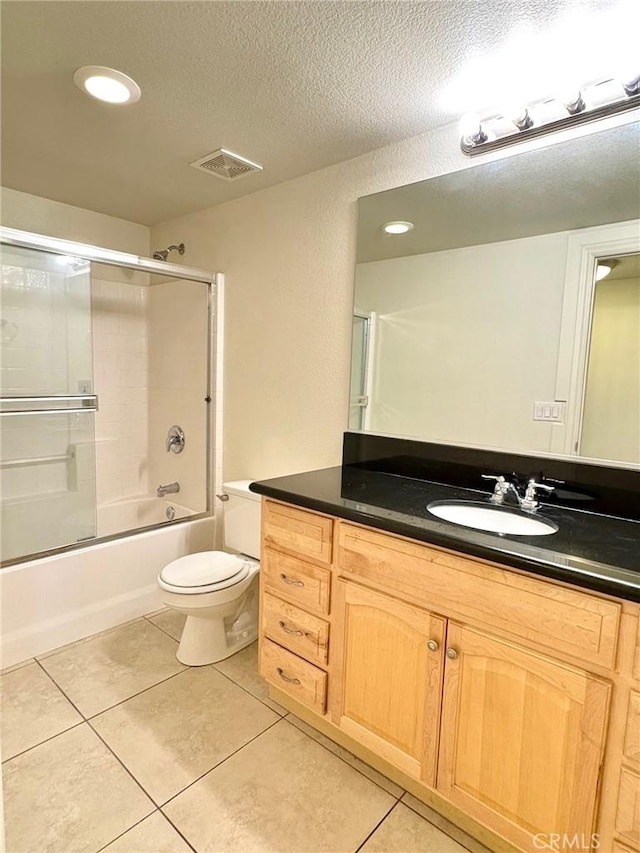 full bathroom featuring enclosed tub / shower combo, toilet, tile patterned flooring, and a textured ceiling