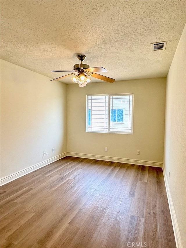 empty room with hardwood / wood-style floors, a textured ceiling, and ceiling fan