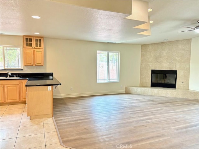 kitchen with light brown cabinetry, a breakfast bar area, a healthy amount of sunlight, and a kitchen island