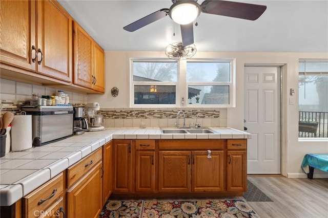 kitchen featuring tasteful backsplash, a healthy amount of sunlight, sink, and tile counters