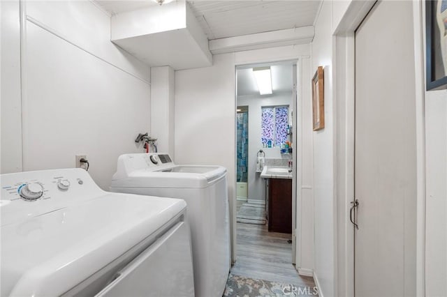 laundry area featuring washer and clothes dryer and light wood-type flooring