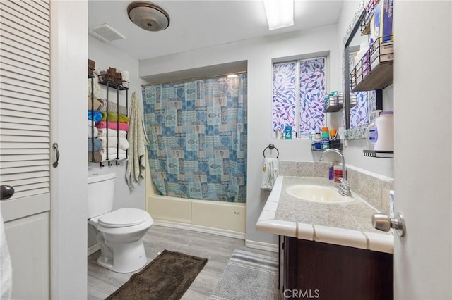 full bathroom with vanity, hardwood / wood-style floors, shower / bath combo, and toilet