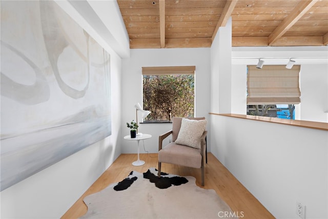 living area with hardwood / wood-style floors, beam ceiling, track lighting, and wooden ceiling