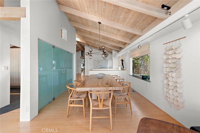 dining space featuring vaulted ceiling with beams, wooden ceiling, light hardwood / wood-style floors, and a chandelier