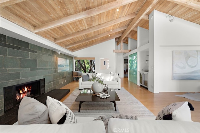 living room featuring hardwood / wood-style floors, beam ceiling, a fireplace, and wooden ceiling