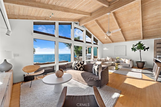 living room with a water view, beamed ceiling, wood ceiling, and hardwood / wood-style flooring